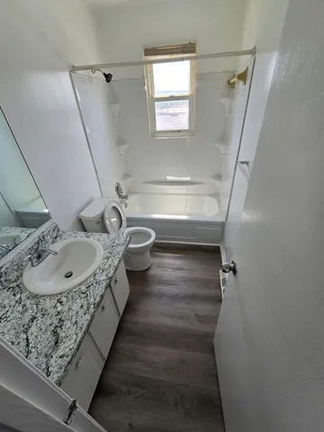 a bathroom with a sink and mirror with toilet