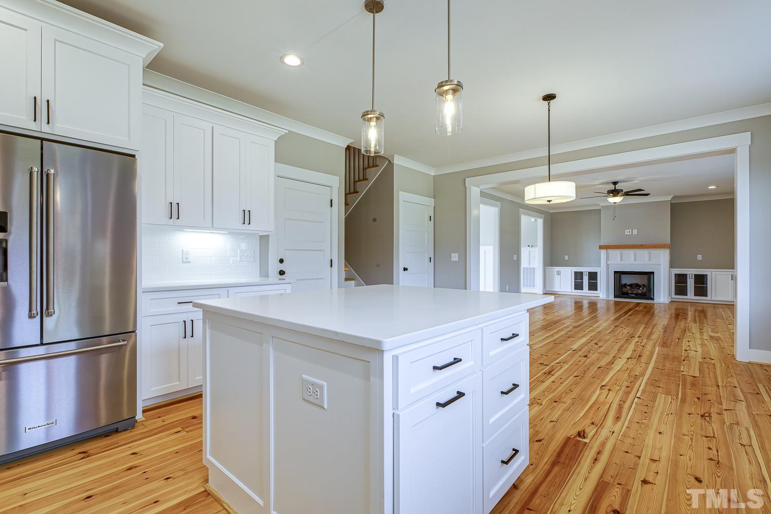 742 River Road Fuquay-Varina, NC 27526 - Photo 25 of 68 a large kitchen with stainless steel appliances kitchen island granite countertop a refrigerator a oven and a island with wooden floor