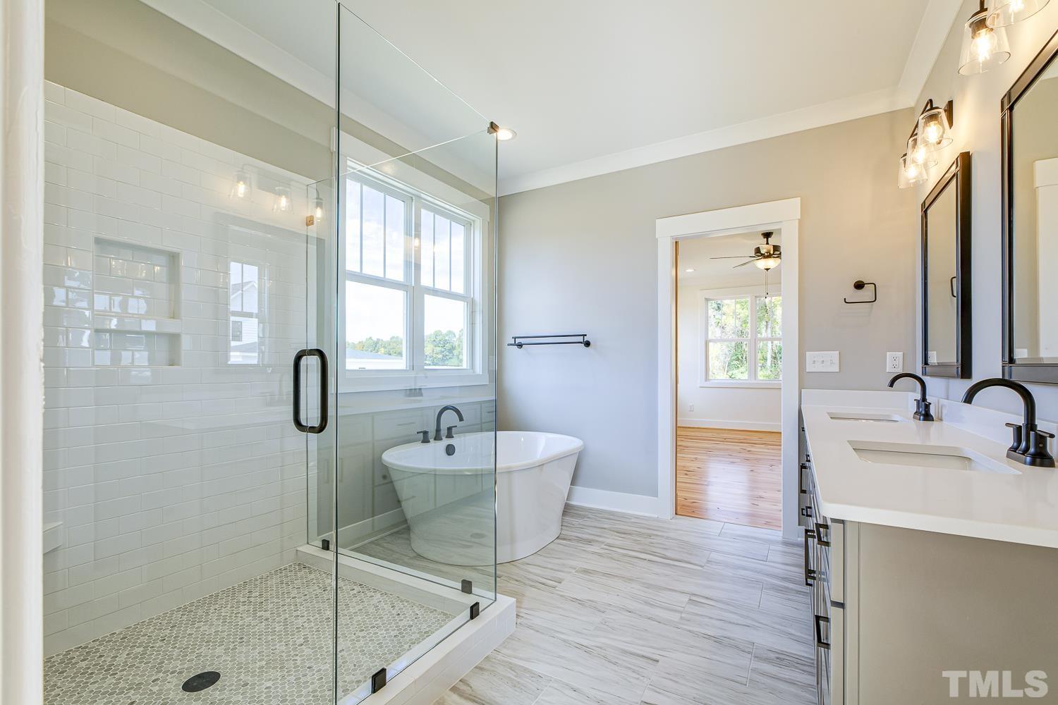 742 River Road Fuquay-Varina, NC 27526 - Photo 40 of 68 a spacious bathroom with a sink a mirror a bathtub and shower