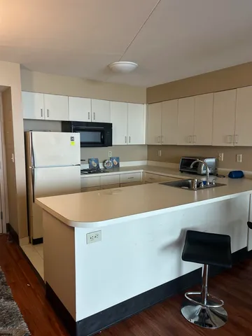 a kitchen with stainless steel appliances a sink a stove a refrigerator and cabinets