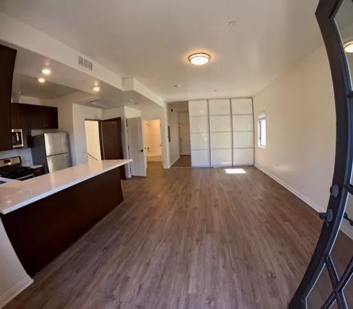 a view of a big room with wooden floor and a window