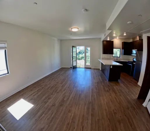 a view of a living room hardwood floor and a window