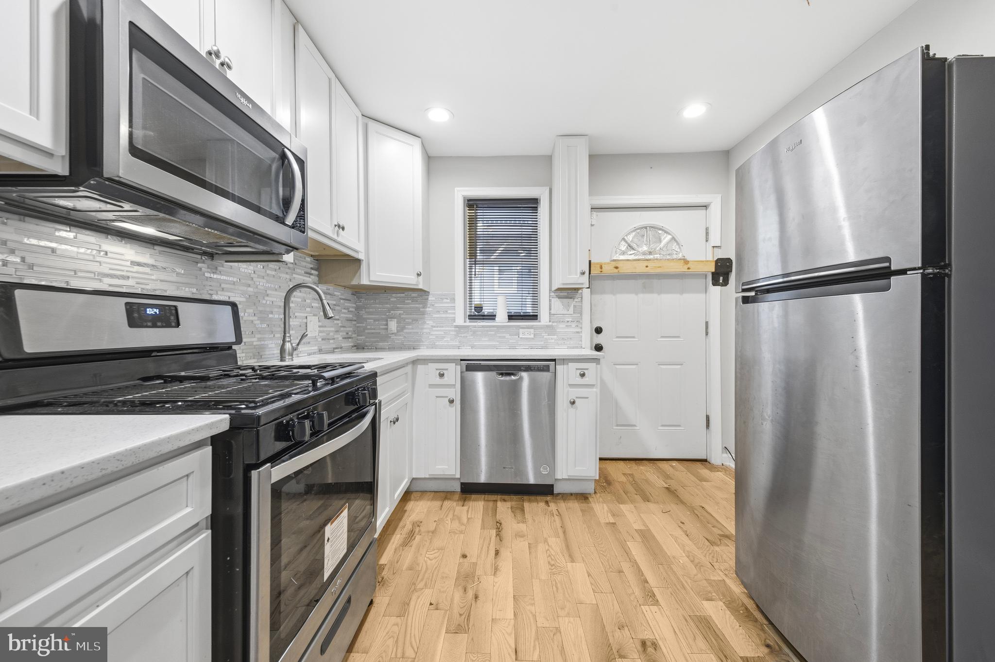 714 North Duncan Street Baltimore, MD 21205 - Photo 12 of 24 a kitchen with a stove microwave and a refrigerator