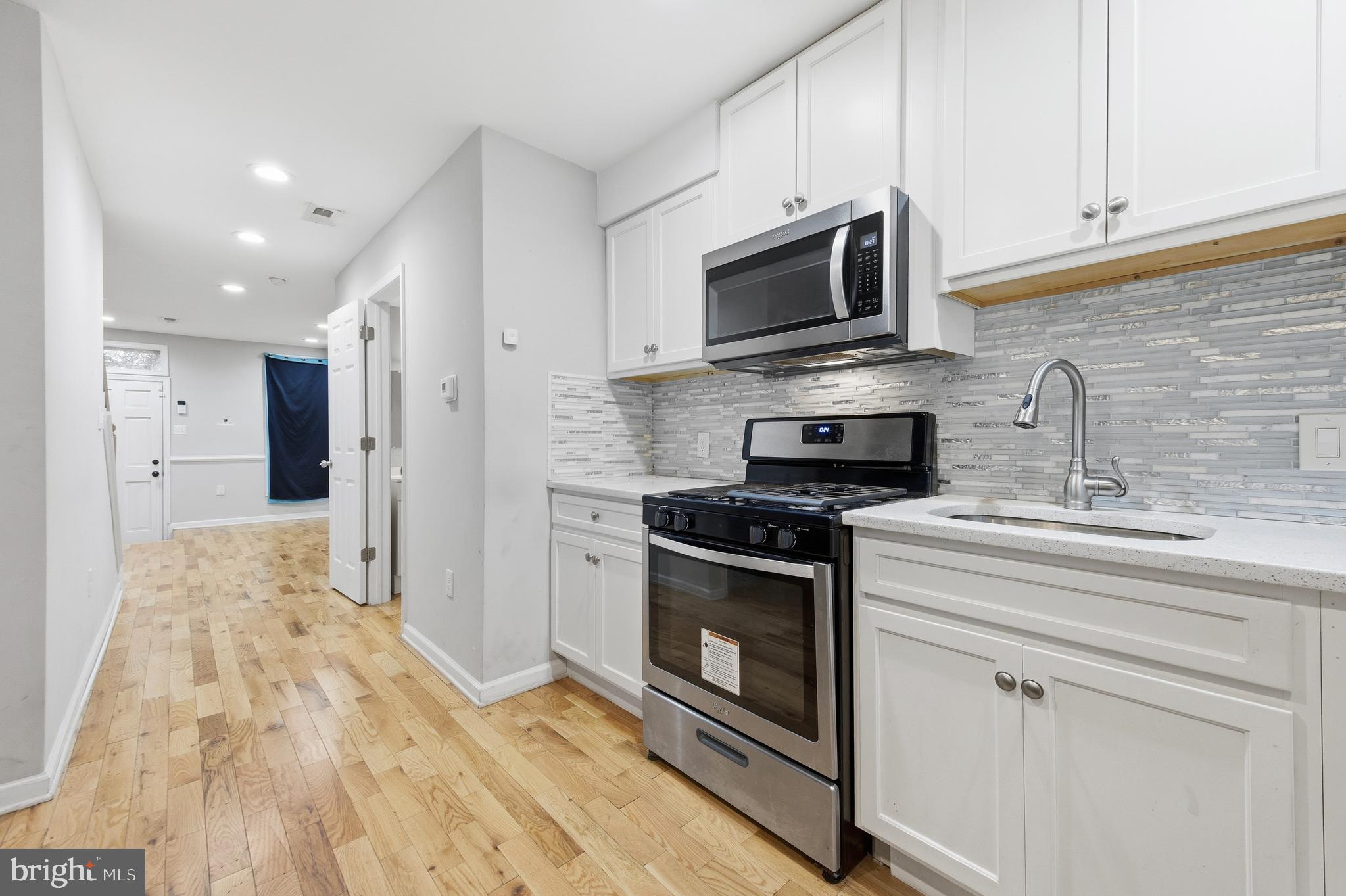 714 North Duncan Street Baltimore, MD 21205 - Photo 13 of 24 a kitchen with stainless steel appliances granite countertop a stove a sink and a microwave