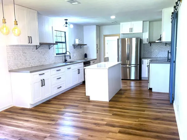 a kitchen with stainless steel appliances kitchen island granite countertop a refrigerator stove and oven