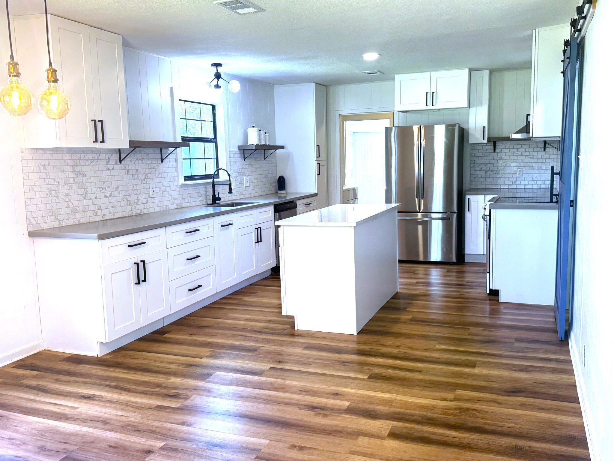 1207 Half Moon Drive Wharton, TX 77488 - Photo 21 of 50 a kitchen with stainless steel appliances a refrigerator sink and wooden floor