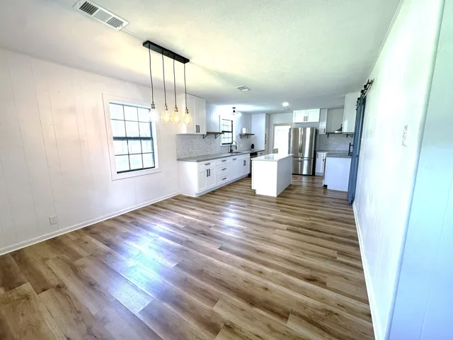 a bathroom with a double vanity sink and mirror with window