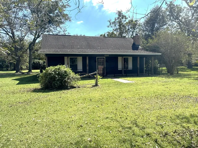 a front view of a house with a yard and trees
