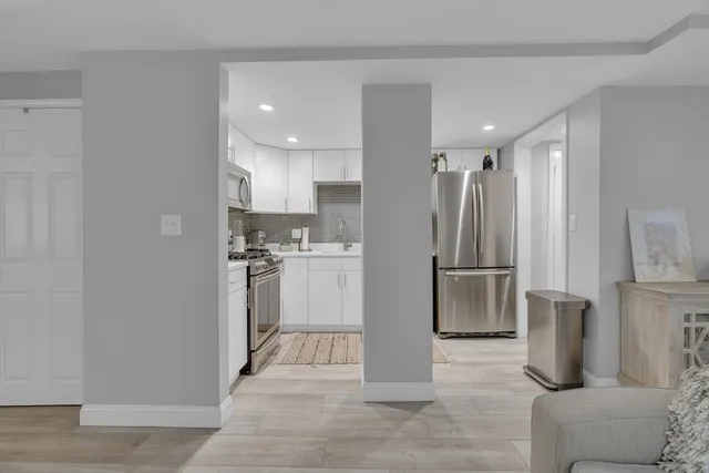a kitchen with white cabinets and stainless steel appliances