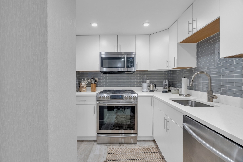 14 Auburn Street, Unit A Boston, MA 02129 - Photo 7 of 10 a kitchen with stainless steel appliances granite countertop a sink stove and microwave