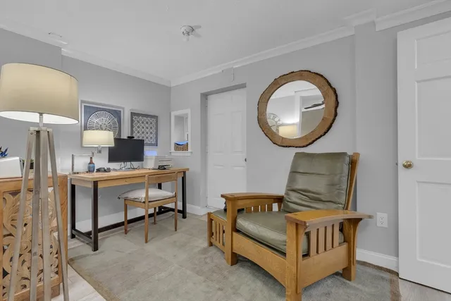 a living room with furniture a mirror and a clock on the table