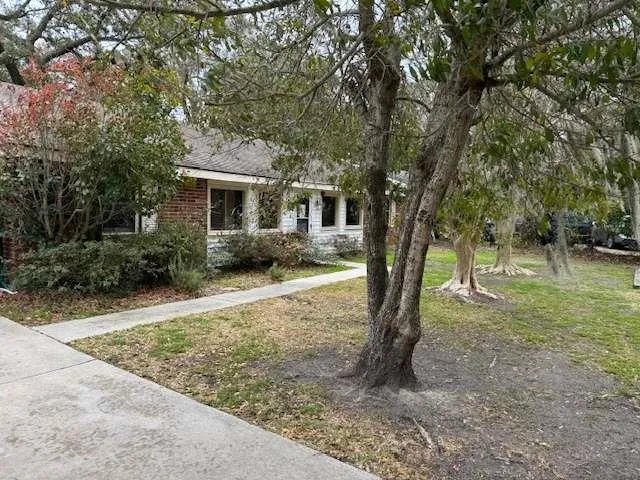 a view of a house with backyard and trees