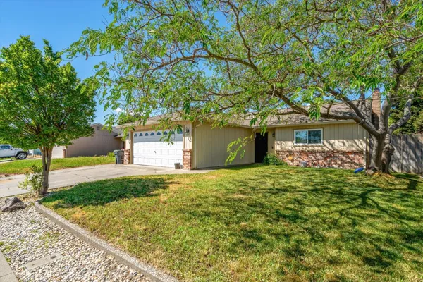 a front view of a house with a yard and trees
