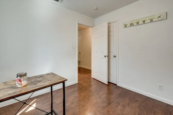 a view of a livingroom and wooden floor and a bathroom