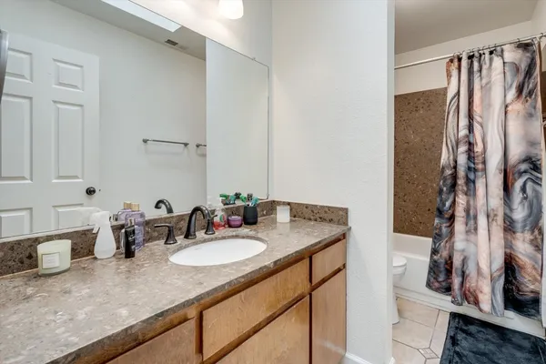 a bathroom with a granite countertop sink and a mirror