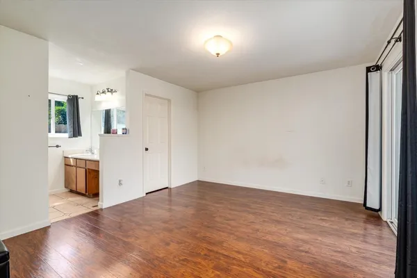 a view of a big room with wooden floor and windows
