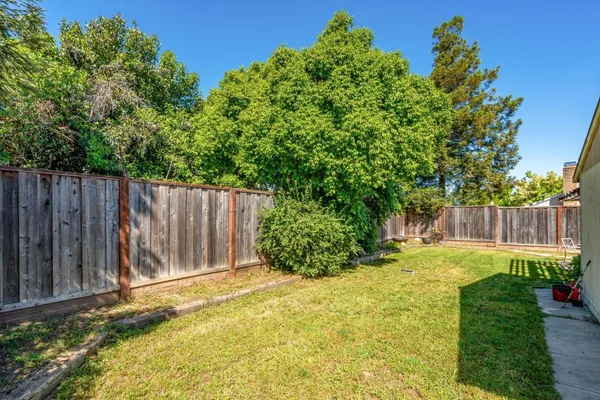 a view of small yard with wooden fence