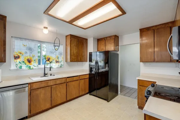 a kitchen with stainless steel appliances granite countertop a refrigerator and a sink