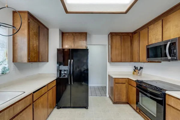 a kitchen with stainless steel appliances granite countertop a refrigerator and a stove top oven