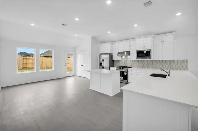 a kitchen with stainless steel appliances a refrigerator sink and microwave