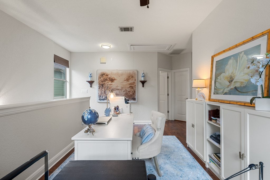 6708 Menchaca Road, Unit 2 Austin, TX 78745 - Photo 15 of 30 Dedicated office space featuring rich wood-finish flooring, a white desk, and built-in white cabinetry with open shelving