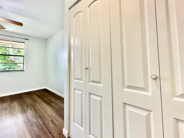 a view of a hallway with wooden floor and a window