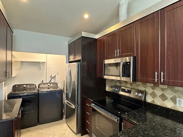 a kitchen with a refrigerator and a stove top oven