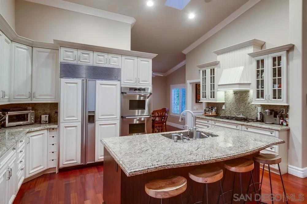 14476 Trailwind Road Poway, CA 92064 - Photo 22 of 61 a kitchen with stainless steel appliances granite countertop a kitchen island hardwood floor sink and stove
