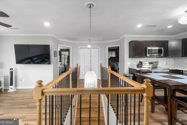 a kitchen with stainless steel appliances granite countertop table chairs sink refrigerator and microwave