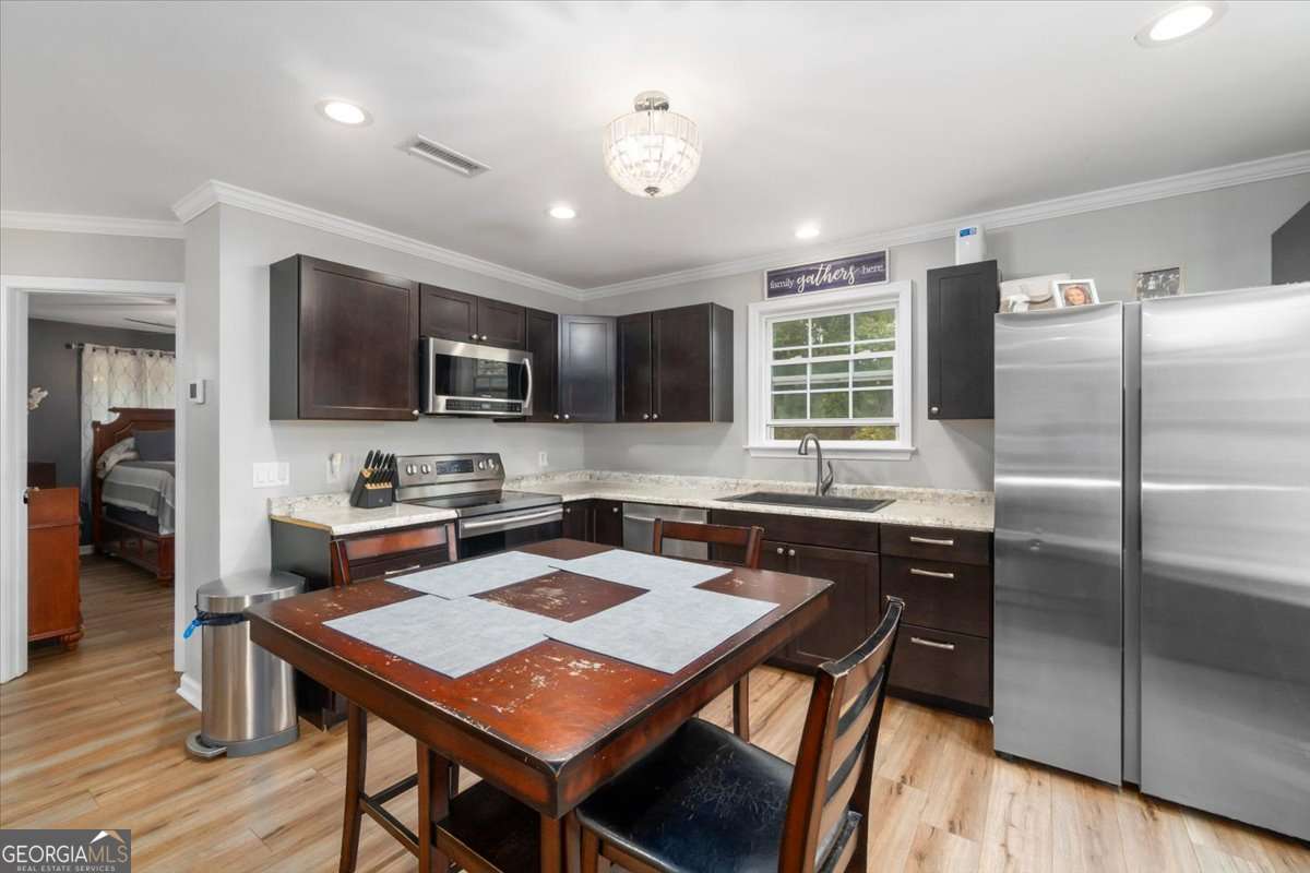 161 Archer Grove Road Athens, GA 30607 - Photo 13 of 56 a kitchen with a stove a sink dishwasher a refrigerator and wooden cabinets with wooden floor