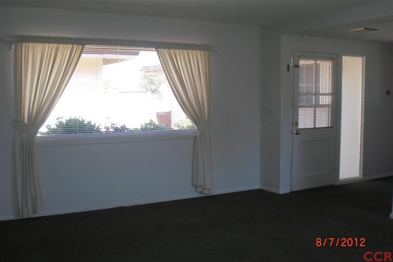 4108 Rigel Avenue Lompoc, CA 93436 - Photo 9 of 16 a view of an empty room with wooden floor and a window