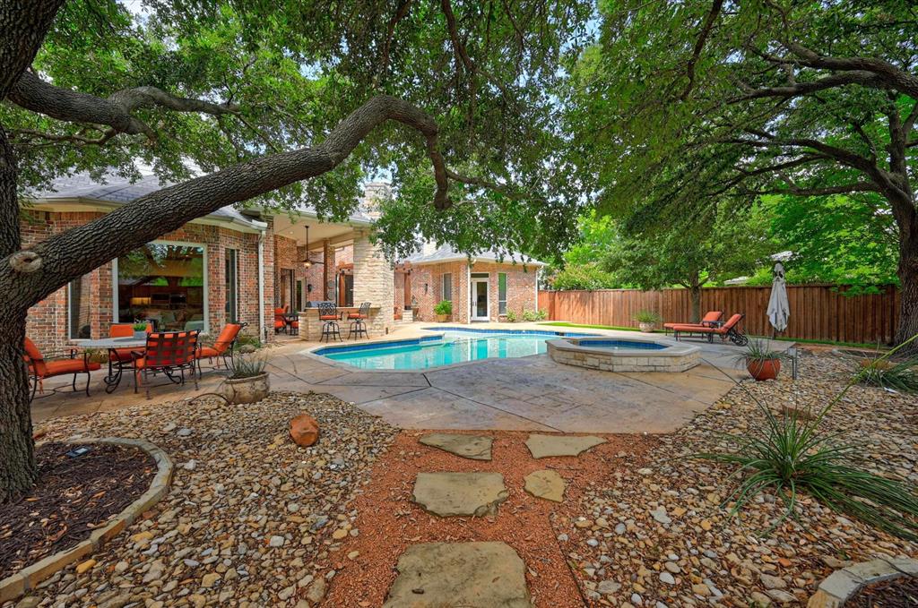 6416 Riverside Drive Plano, TX 75024 - Photo 30 of 35 Expansive outdoor living area featuring a custom swimming pool, integrated spa, and mature shade trees