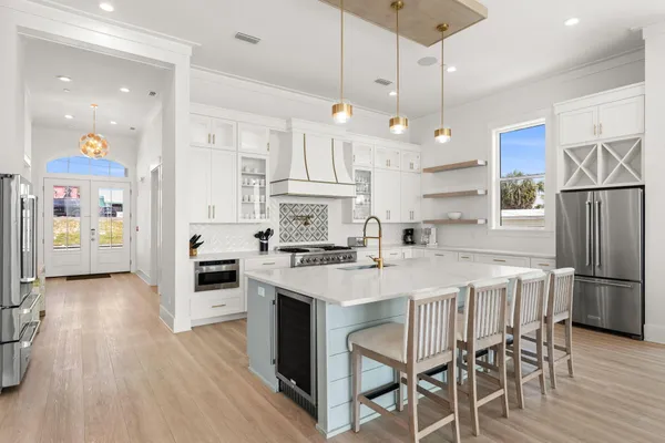 a living room with furniture kitchen view and a large window