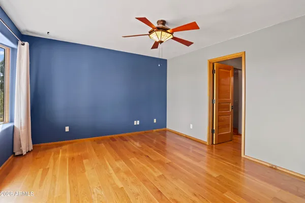 a view of a big room with wooden floor and a ceiling fan