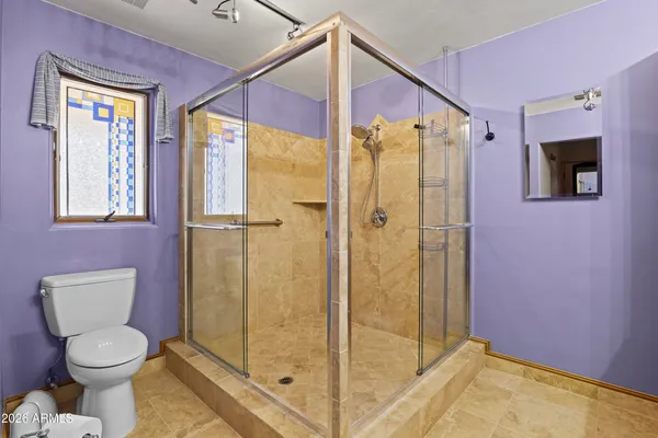 a bathroom with a toilet and a shower
