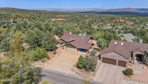 an aerial view of residential houses with outdoor space and trees