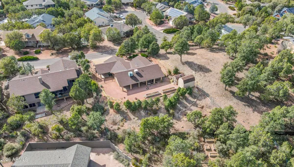 an aerial view of residential house with outdoor space and trees all around