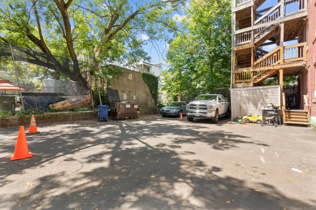 a view of a white house with a yard and potted plants
