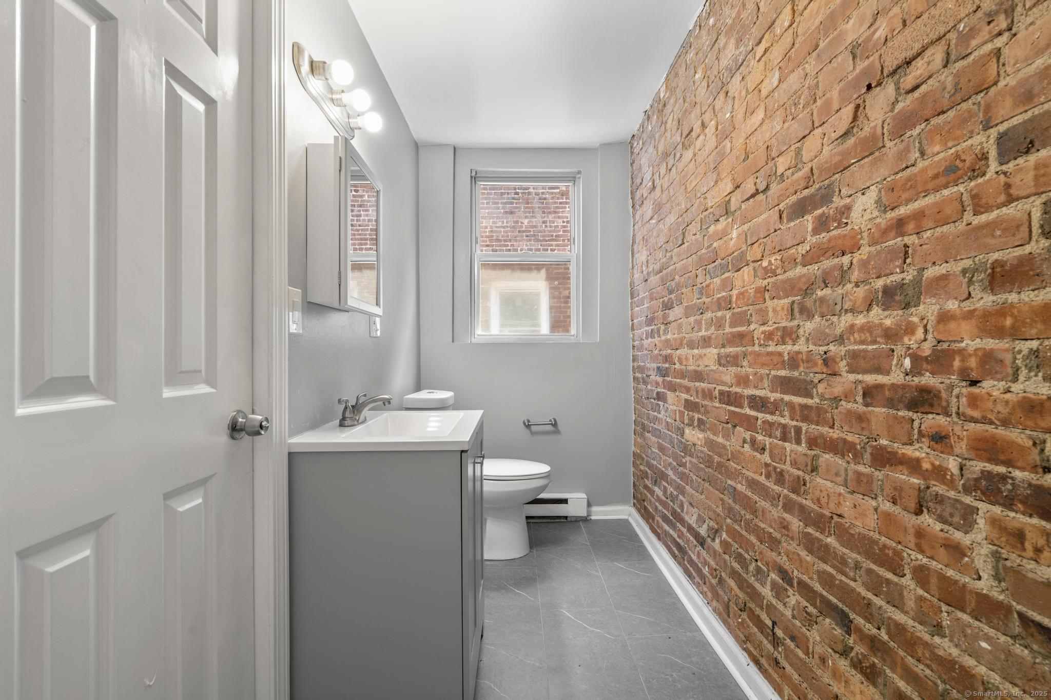 31 Whittier Street Bridgeport, CT 06605 - Photo 24 of 34 a bathroom with a toilet a sink and mirror