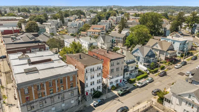 an aerial view of a residential apartment building with a yard and mountain view in back