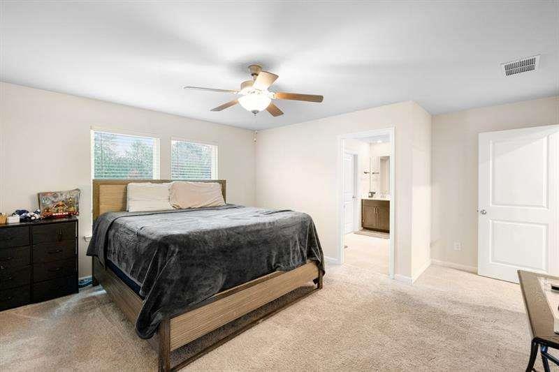1070 Sunny Lk Drive Lawrenceville, GA 30043 - Photo 25 of 33 a spacious bedroom with a bed and a chandelier