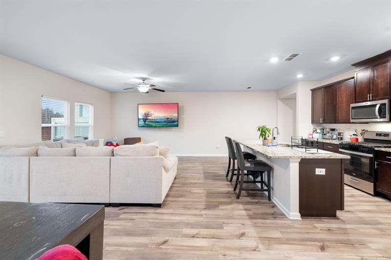 1070 Sunny Lk Drive Lawrenceville, GA 30043 - Photo 6 of 33 a living room with furniture a wooden floor and a kitchen view