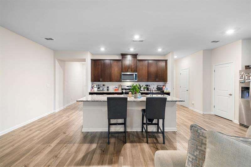 1070 Sunny Lk Drive Lawrenceville, GA 30043 - Photo 9 of 33 a kitchen with a dining table chairs refrigerator and cabinets