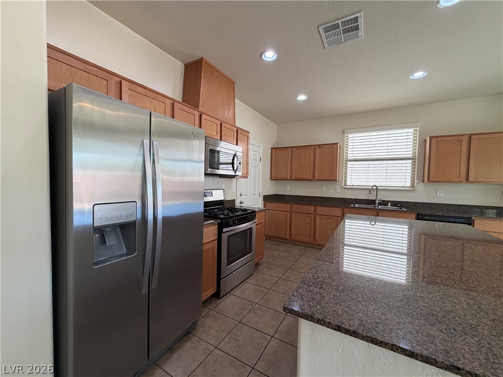442 White Heart Road Las Vegas, NV 89148 - Photo 8 of 25 Polished stone countertops pair with classic wood cabinetry and durable tile flooring.