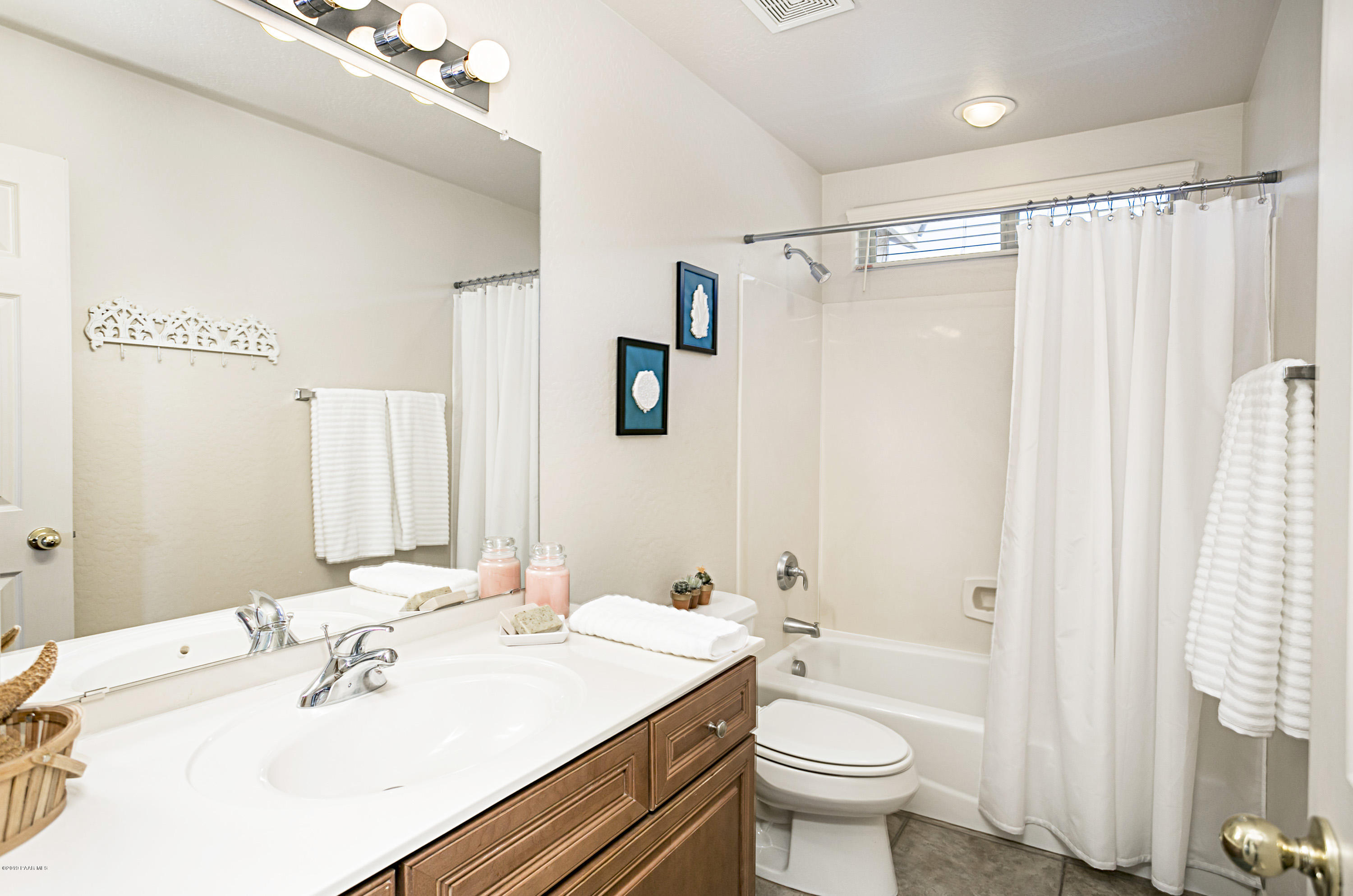 7257 Woolsey Ranch Road Prescott Valley, AZ 86314 - Photo 14 of 31 a bathroom with a sink a toilet and shower curtain