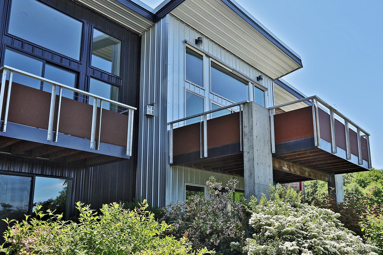 1649 Stewart Road Freeland, WA 98249 - Photo 8 of 40 a view of a house with large windows and flower plants