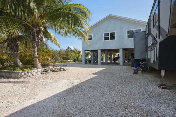 a living room with stainless steel appliances kitchen island granite countertop furniture a kitchen island a stove a refrigerator cabinets and wooden floor