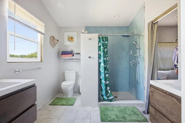 a bedroom with a bed and a flat tv screen on dresser