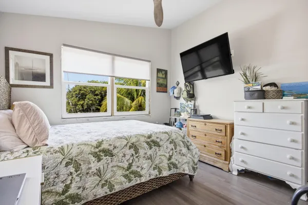 a bedroom with a bed a flat screen tv and window