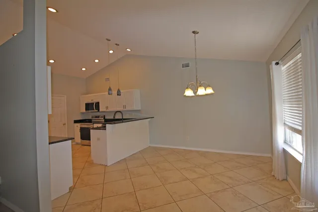 a kitchen with stainless steel appliances a refrigerator and a stove top oven